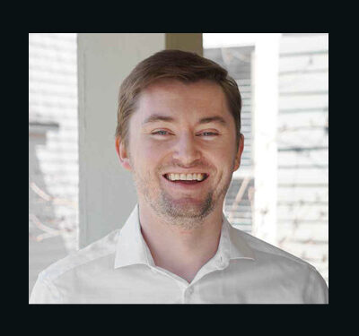 Photo of Sean McCann, man with short brown hair wearing a white shirt