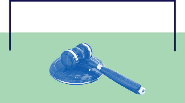 Gavel laying on its side with a blue and white color overlay on a green and white background