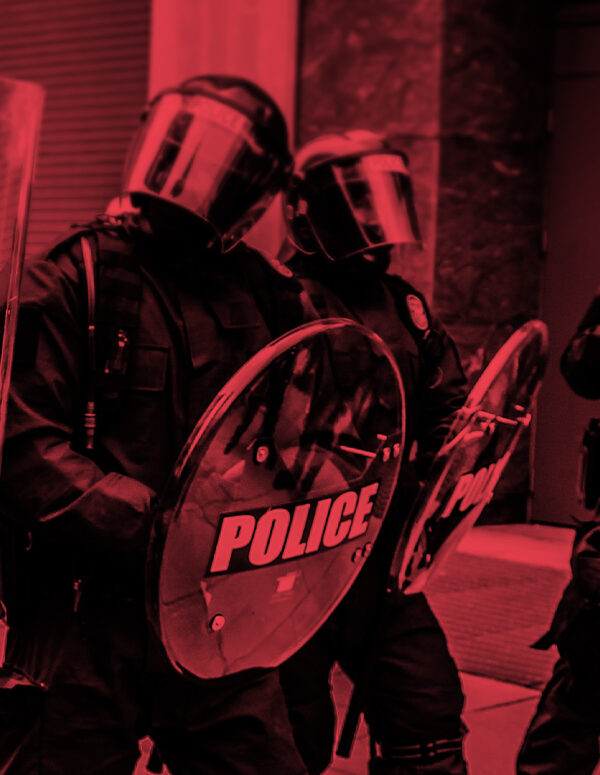 Photo of militarized police in riot gear with a black and red color overlay