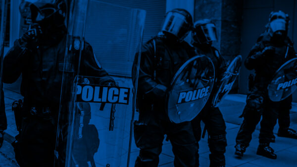 Militarized police in riot gear with a black and blue color overlay