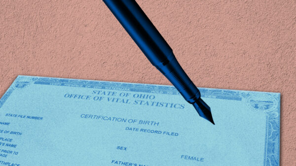 Ohio Birth Certificate with an azure color overlay and a pen with a blue color overlay, on a textured pink background