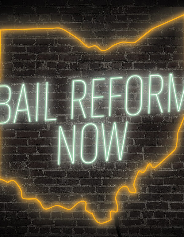 Bail Reform Now neon sign with the ourline of ohio in green and orange on a dark brick background