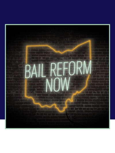 'Bail Reform Now' neon sign on a black brick background
