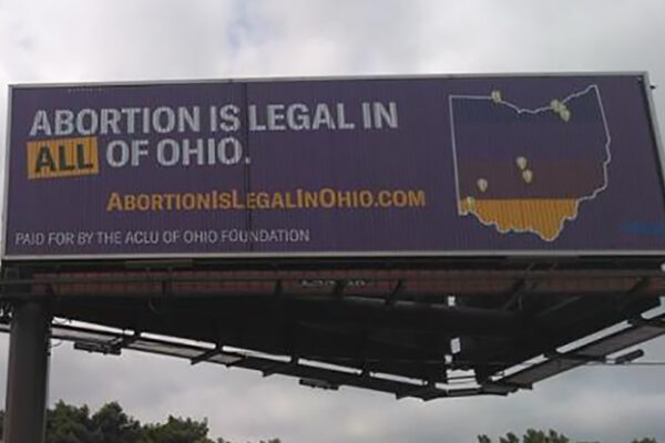 Billboard with a purple background that reads "Abortion is legal in ALL of Ohio" and includes an image of the state of Ohio with map markers showing existing abortion clinics