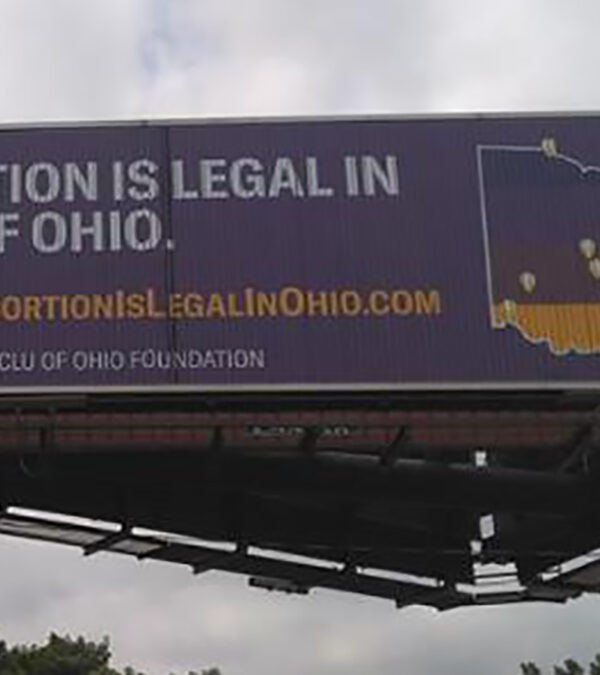 Billboard with a purple background that reads "Abortion is legal in ALL of Ohio" and includes an image of the state of Ohio with map markers showing existing abortion clinics