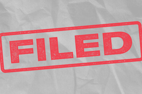 The word 'Filed' in red font, mimicking a rubber stanmp on a light grey textured background