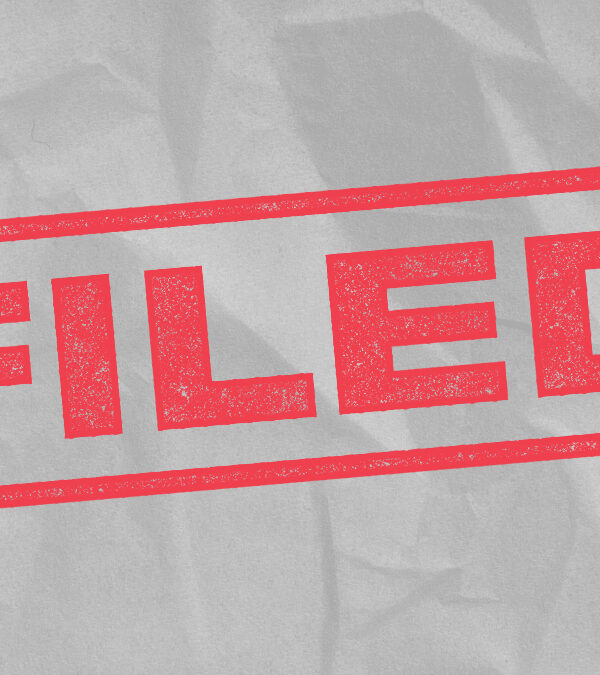 The word 'Filed' in red font, mimicking a rubber stanmp on a light grey textured background