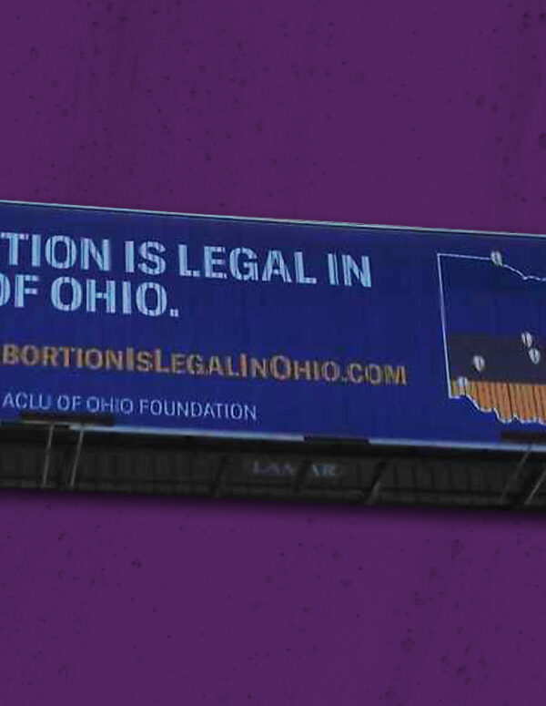 A billboard stating 'Abortion is legal in all of Ohio' with the state of Ohio on a purple textured background