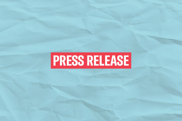 The words 'Press Release' in white font on a red rectangle on an azure paper texture background