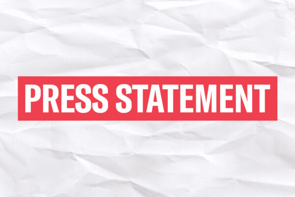 The words 'Press Statement' in white font in a red rectangle on a wrinkled white paper background