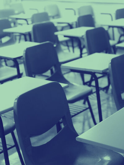 A classroom with empty chairs and desks with a navy and mint color overlay