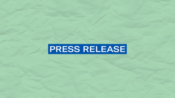 The words 'Press Release' in white font on a blurerectangle on a mint green color paper texture background