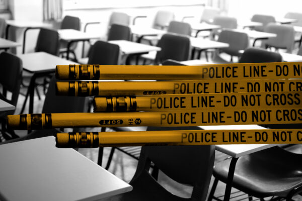 Graphic of yellow pencils combined with police tape stating "Police Line Do Not Cross." Pencils are in front of a black and white photo of a classroom with empty desks.