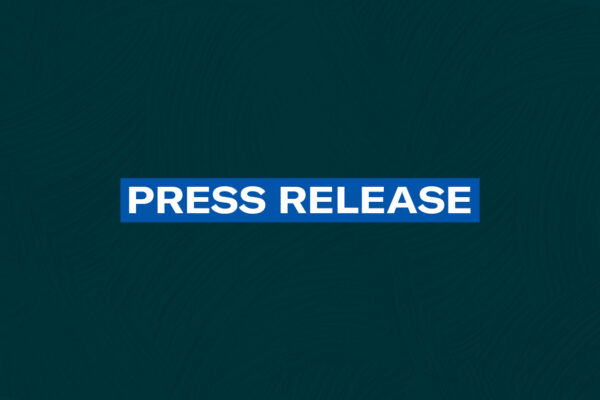 The words 'Press Release' in white font on a blue rectangle on a dark green plaster texture background