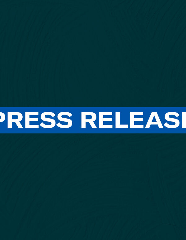 The words 'Press Release' in white font on a blue rectangle on a dark green plaster texture background
