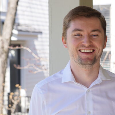 Photo of Sean in white shirt with a tree in the background