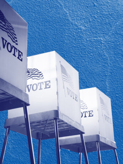 Voting booths with a navy and white color overlay on a concrete textured blue background