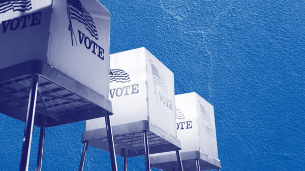 Voting booths with a navy and white color overlay on a concrete textured blue background
