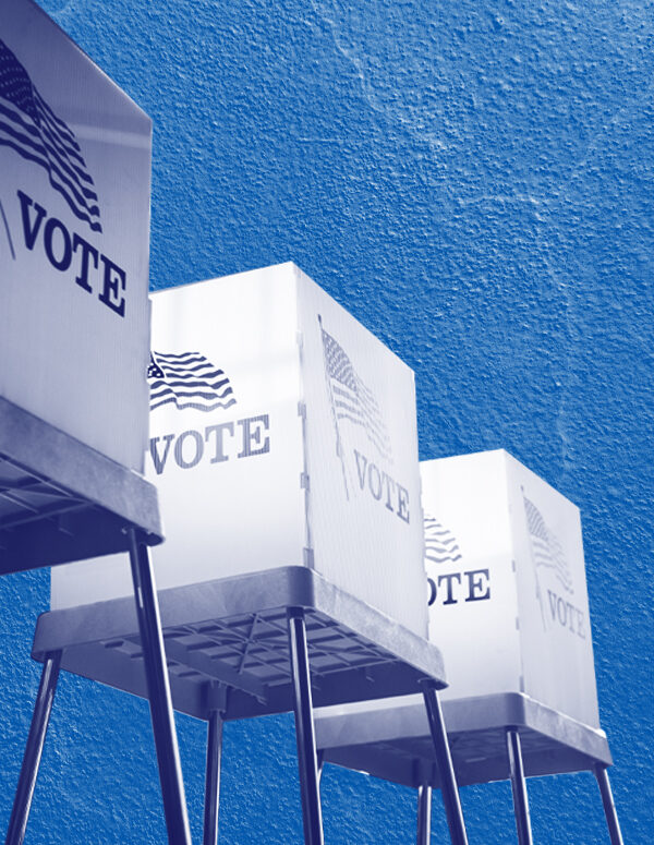 Voting booths with a navy and white color overlay on a concrete textured blue background