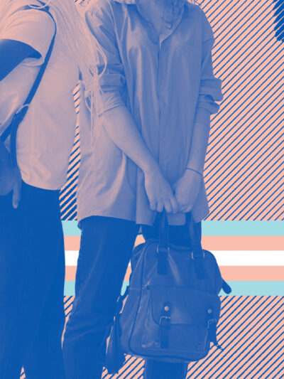 A group of young people standing with backpacks with a trans flag behind thir legs