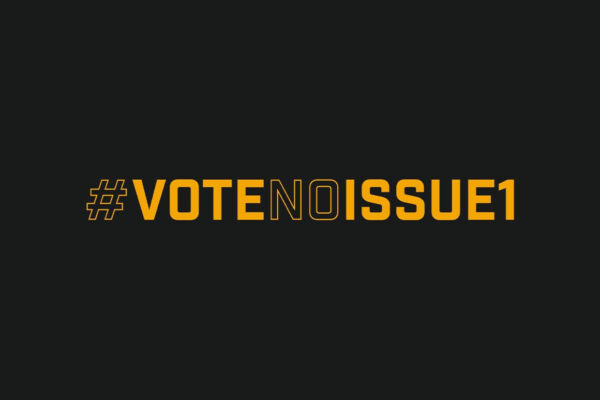 The words 'Vote No Issue 1' in yellow font on a black background