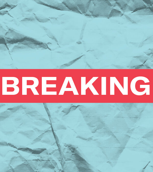 The word 'Breaking' in white font in a red rectangle on a paper textured azure background