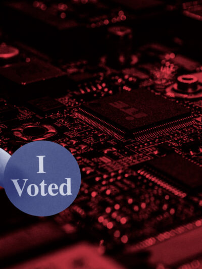 Red electronic background with a hand holding an "I Voted" sticker