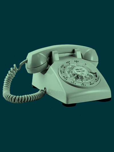 Mint green rotary phone on a dark green background