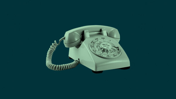Mint green rotary phone on a dark green background