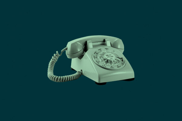 Mint green rotary phone on a dark green background
