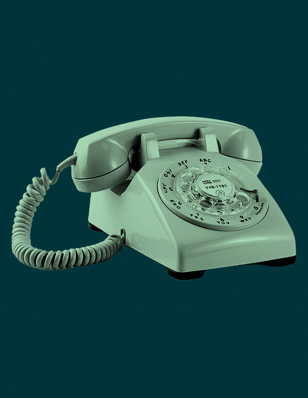 Mint green rotary phone on a dark green background