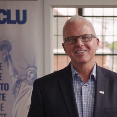 White man with glasses smiling
