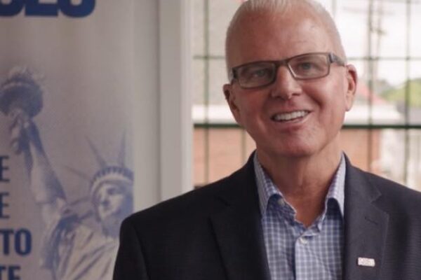 White man with glasses smiling