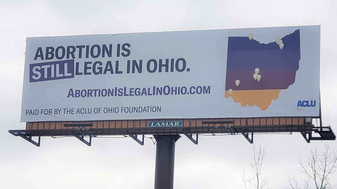 Billboard that says Abortion is still legal in Ohio with a multicolored map of Ohio