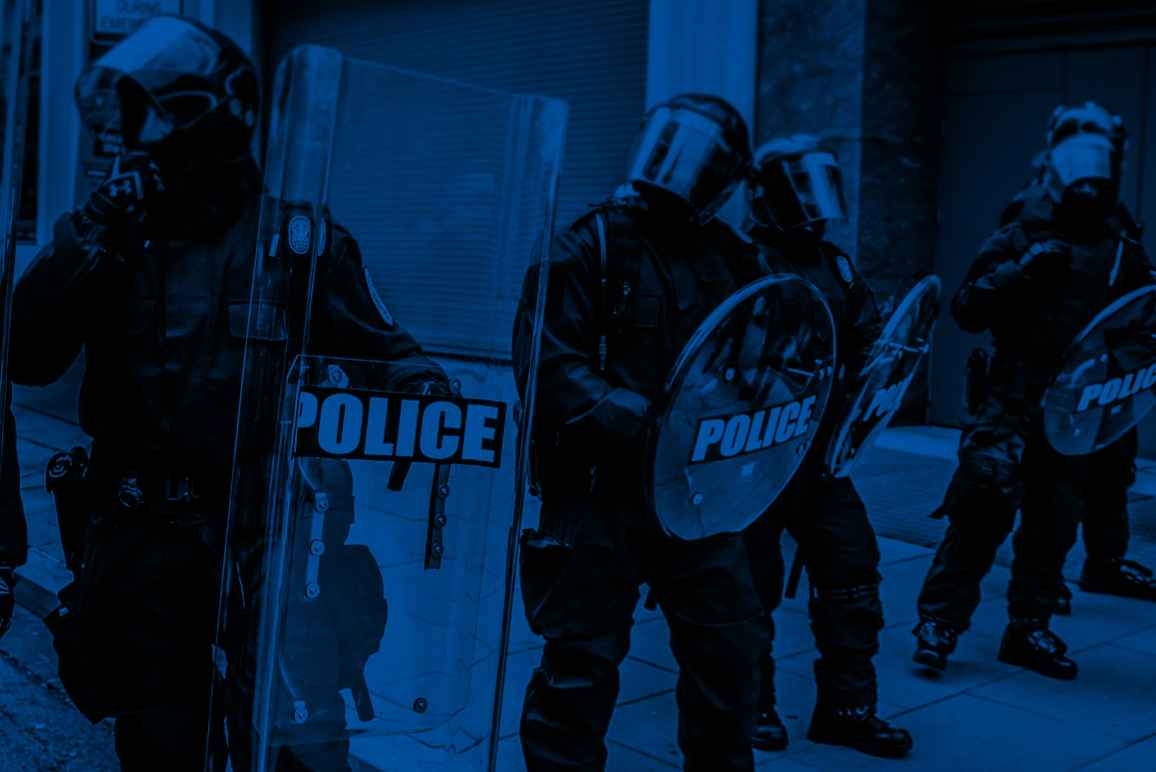 Militarized police in riot gear with a black and blue color overlay