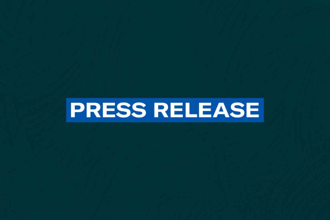 The words 'Press Release' in white font on a blue rectangle on a dark green plaster texture background
