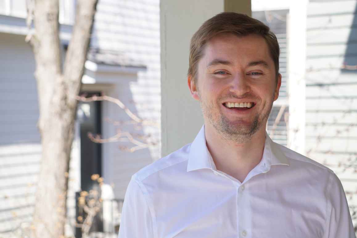 Photo of Sean in white shirt with a tree in the background