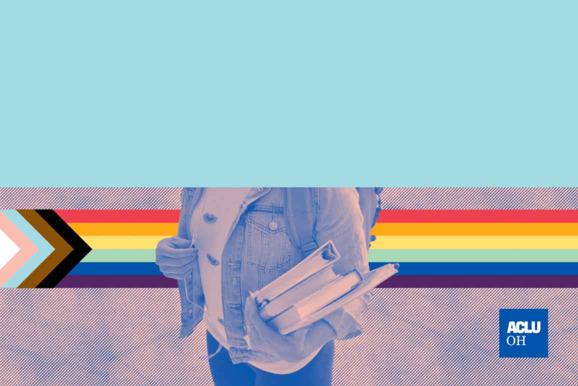 student holding books with pride flag in the background