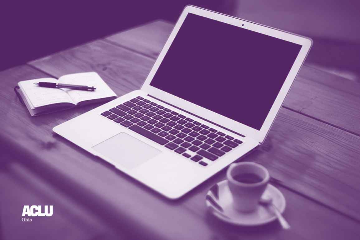 Laptop computer, a cup of coffee, and a small notepad and pen on a wooden desk with purple and white color overlay
