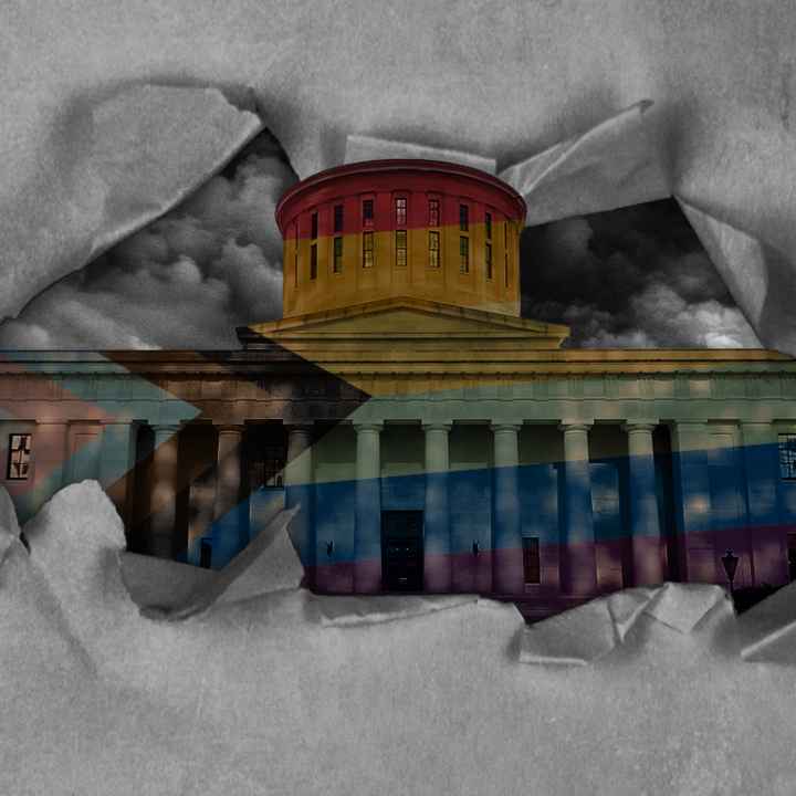 Ohio Statehouse with a pride flag overlay, with dark clouds in the sky, and tearing through paper